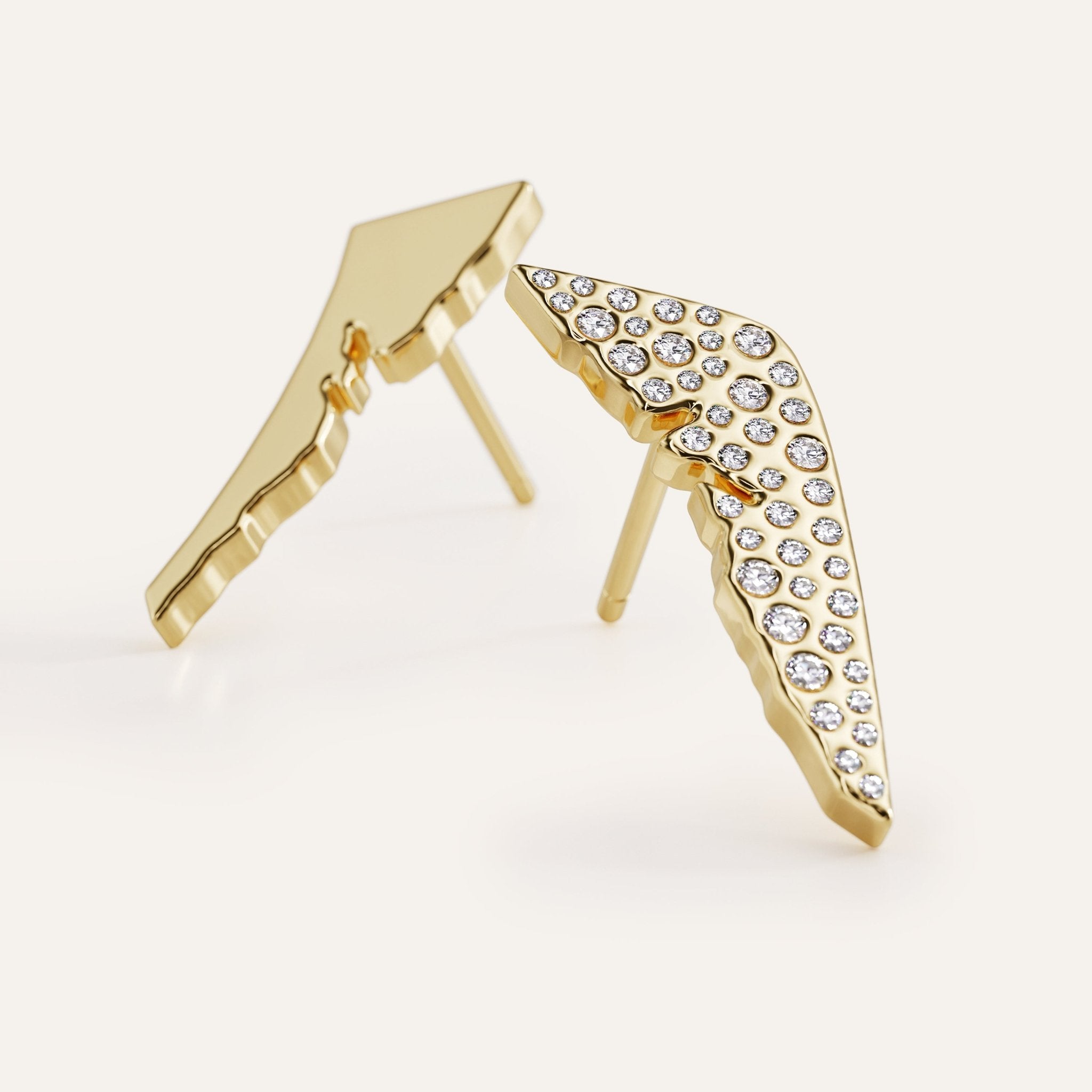 Gold wing-shaped earrings with clear gemstones on a white background