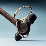 Decorative key with gold rings on a wooden handle against a gradient blue background