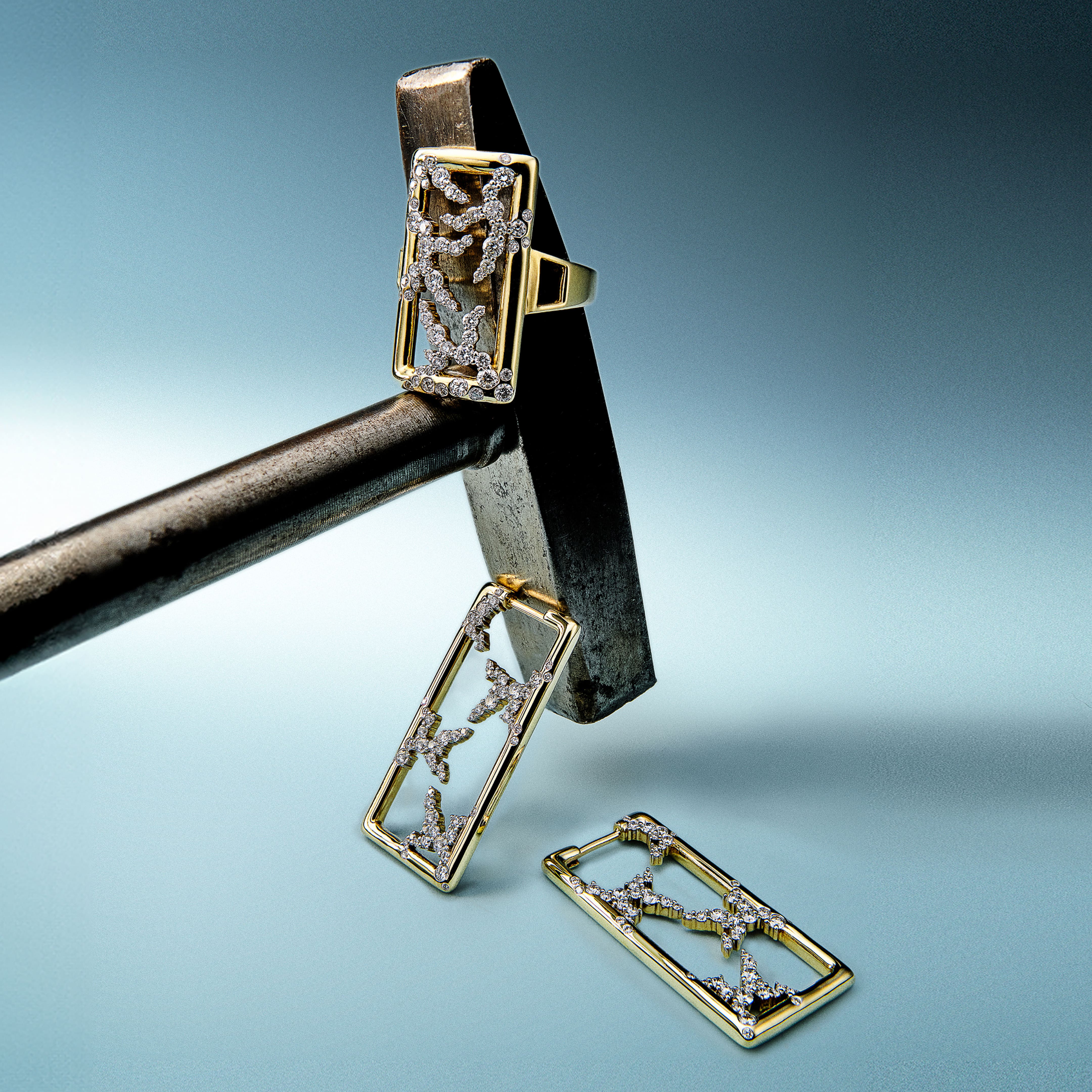 Gold jewelry set with ring, earrings, and pendant on a blue gradient background