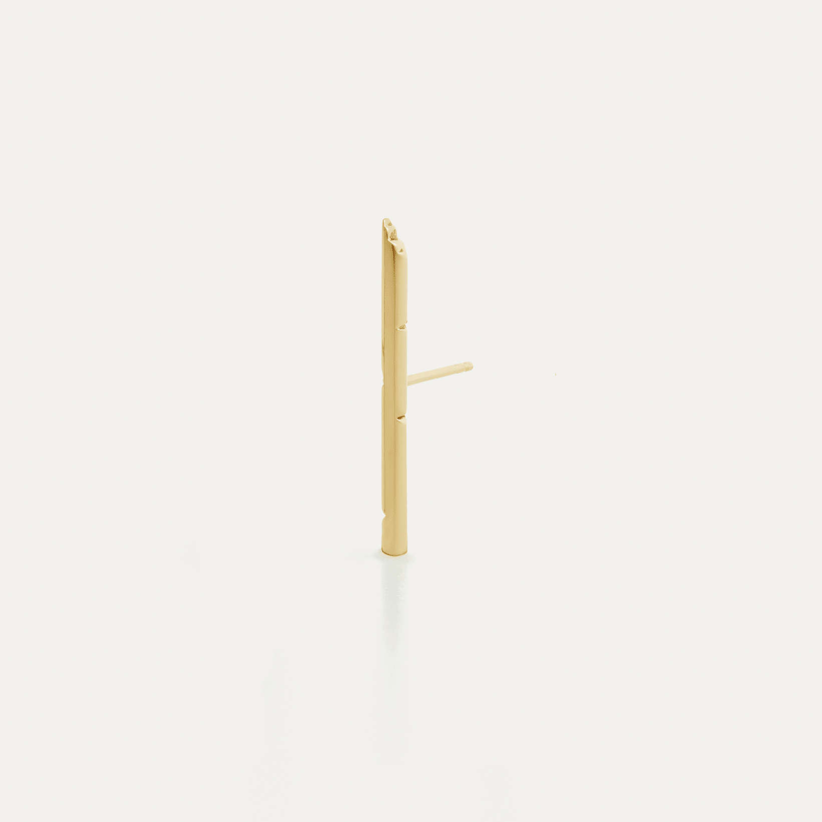 A single gold bar stud earring on a white background, representing a minimalist and modern design.