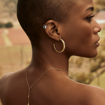 woman wearing gold earring and platinum ear cuff