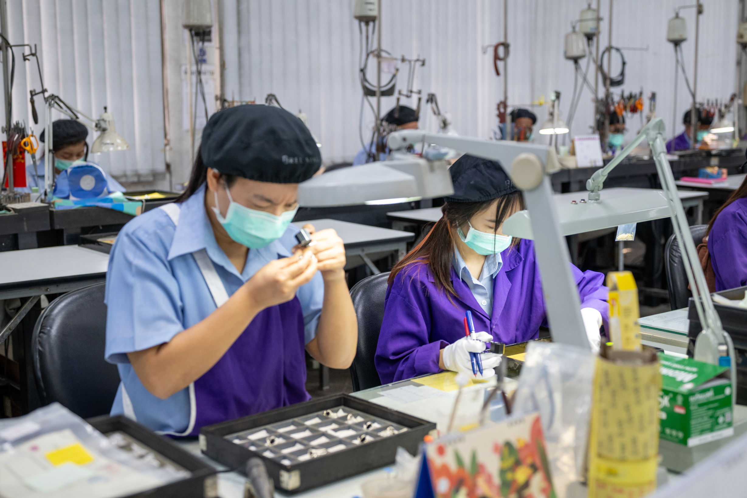 Professionals in workstations evaluating diamonds