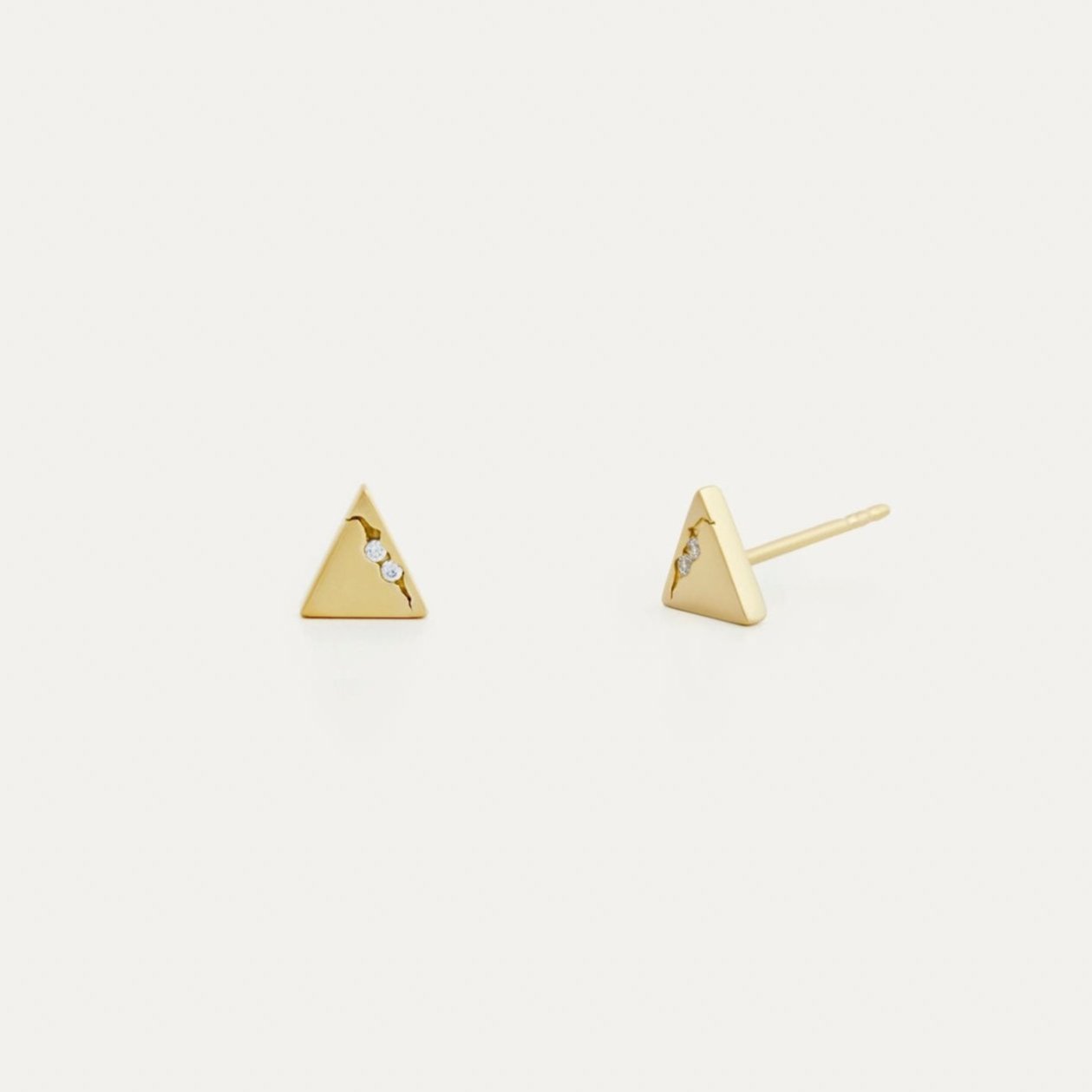 A pair of triangle-shaped stud earrings crafted from yellow gold, featuring pave lab-grown diamonds along one side.