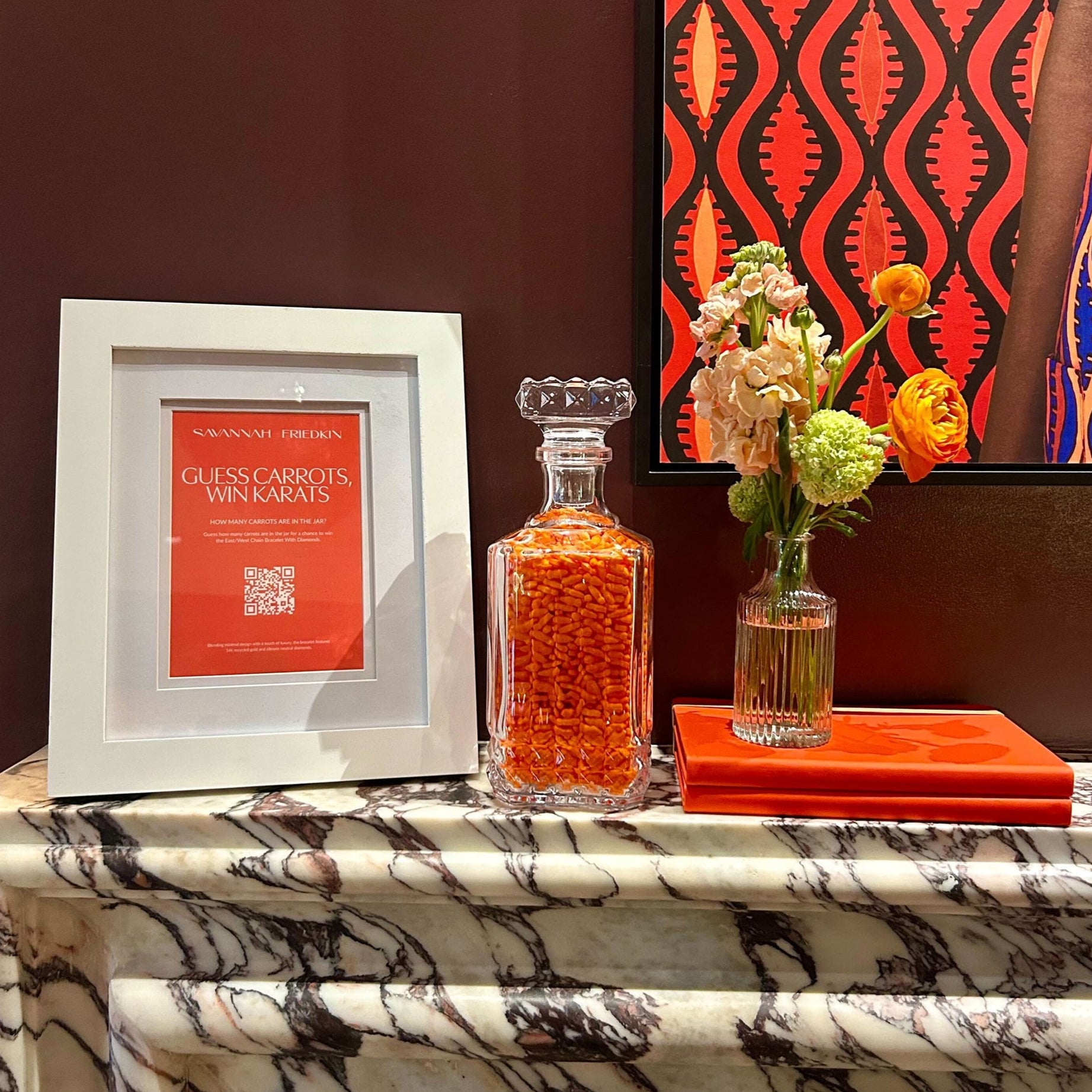 Decorative items on a marble surface with a colorful abstract painting in the background.