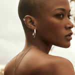 Woman wearing platinum ear cuff with diamonds and gold earring with diamonds