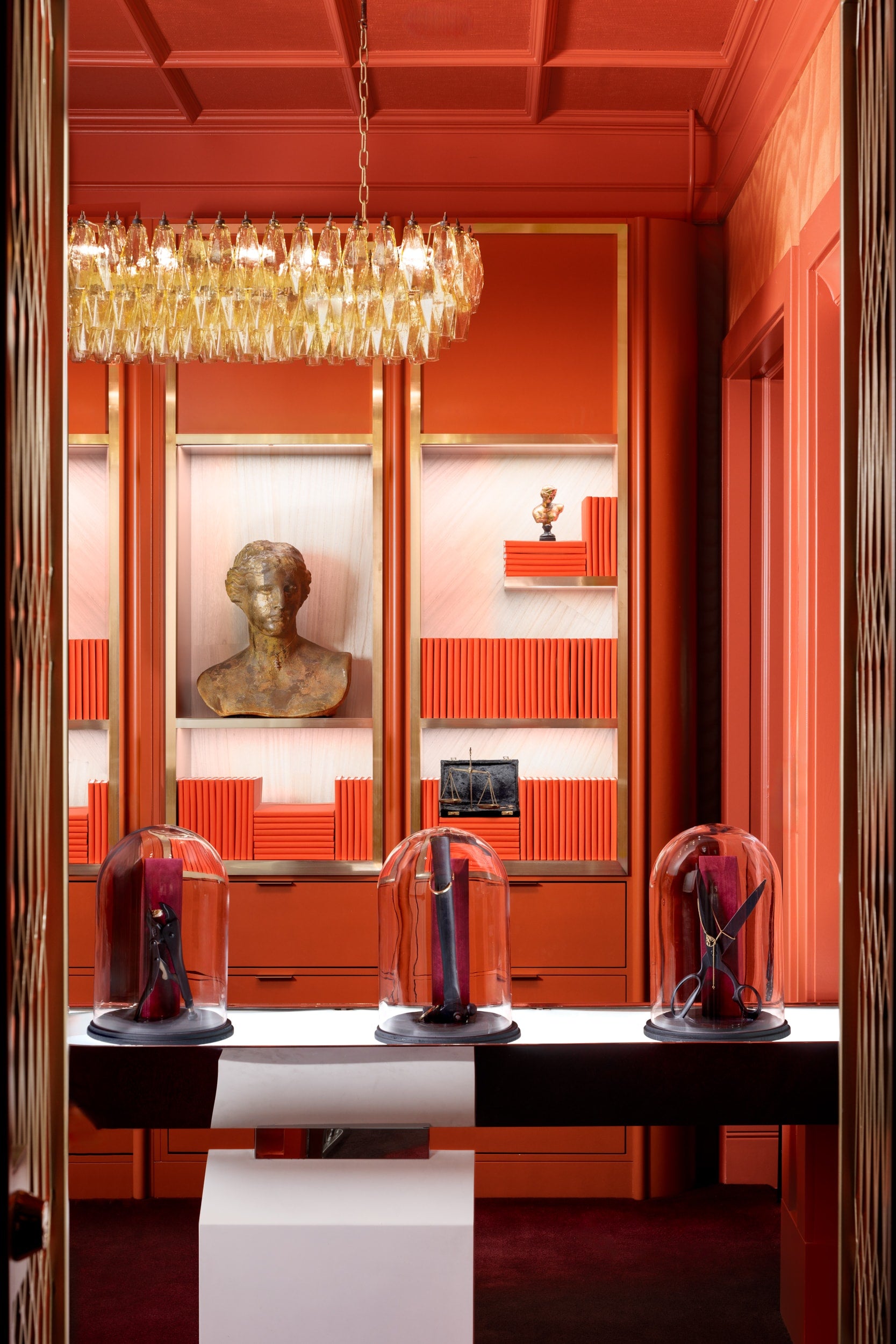 Luxurious interior with red walls, a chandelier, and decorative items.