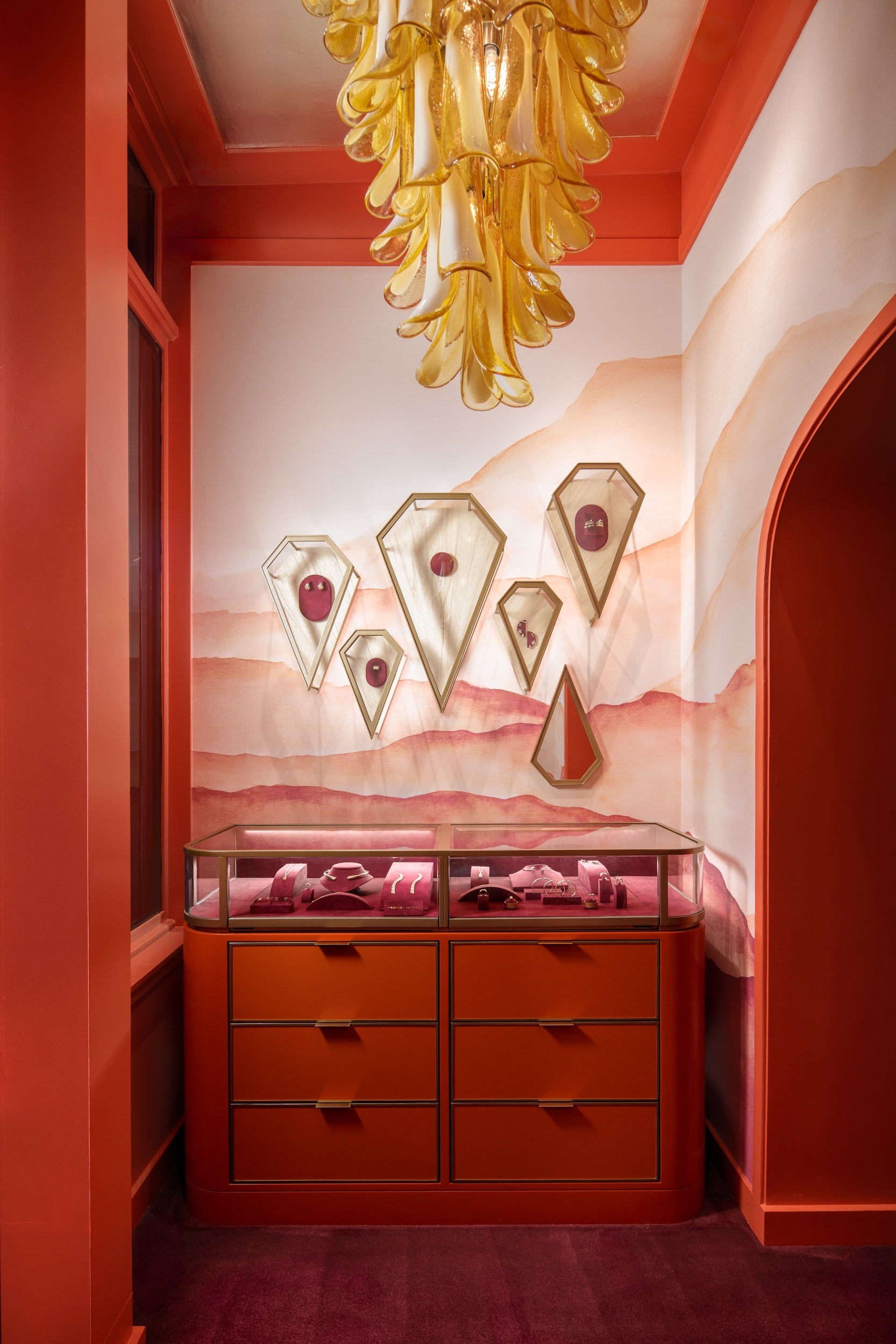 Luxury jewelry display with red cabinets and gold chandelier