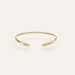 Gold bracelet on a light beige background