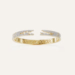 Gold bracelet with diamond accents on a light beige background