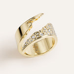 Gold ring with diamond accents on a light beige background