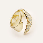 Gold ring with diamond accents on a light beige background