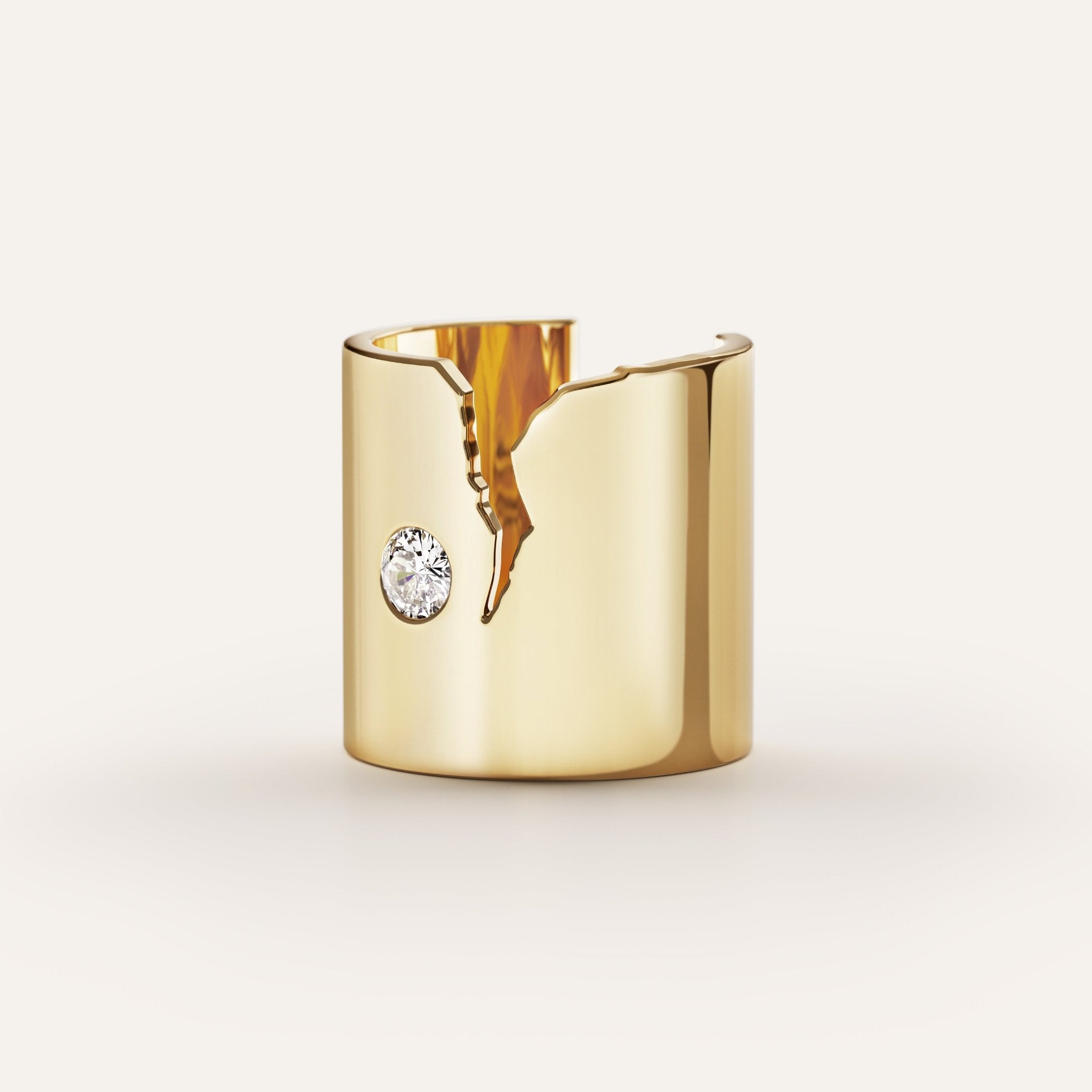 Gold cuff bracelet with a central gemstone on a light gray background