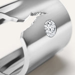 Close-up of a silver ring with a diamond on a light background