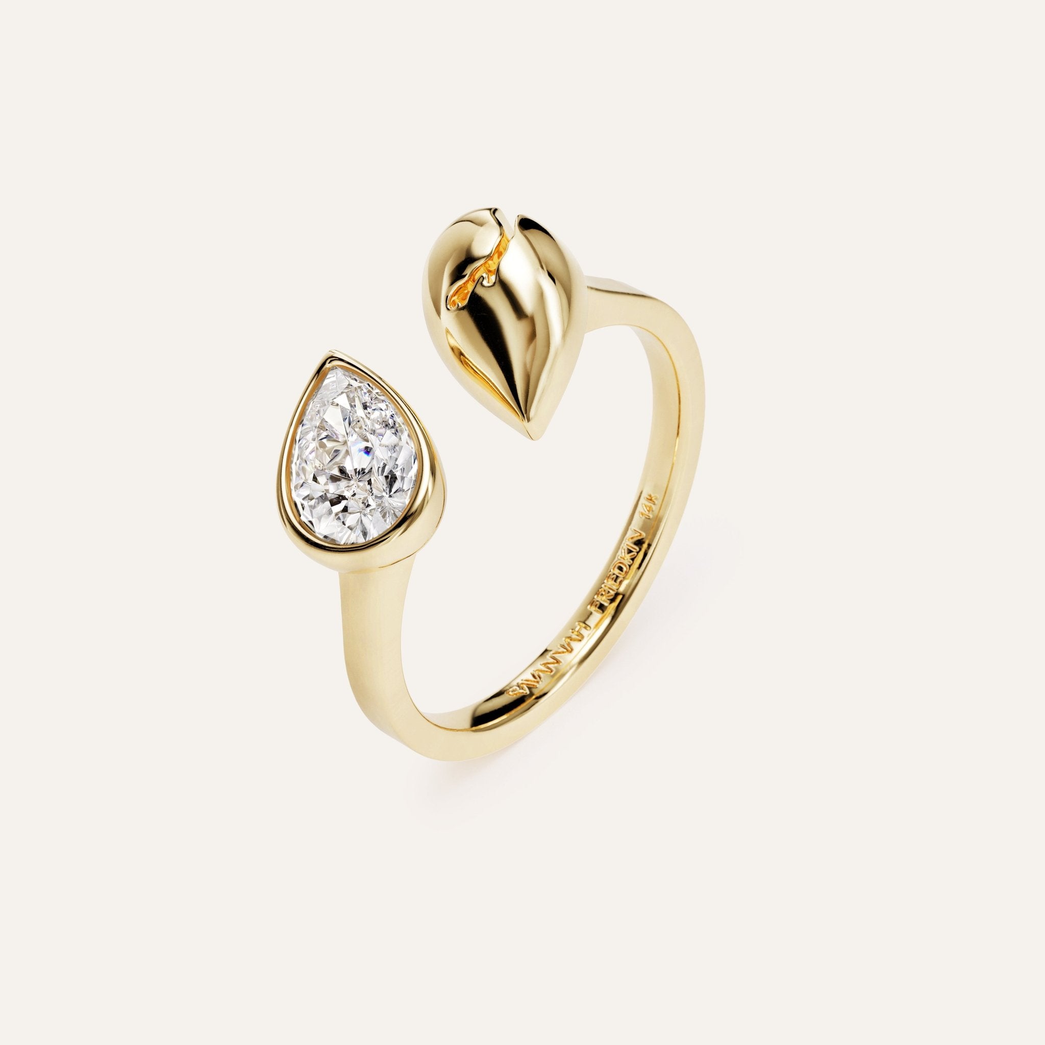 Gold ring with a heart-shaped top and diamond on a white background