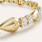 Gold bracelet with three diamonds on a light background
