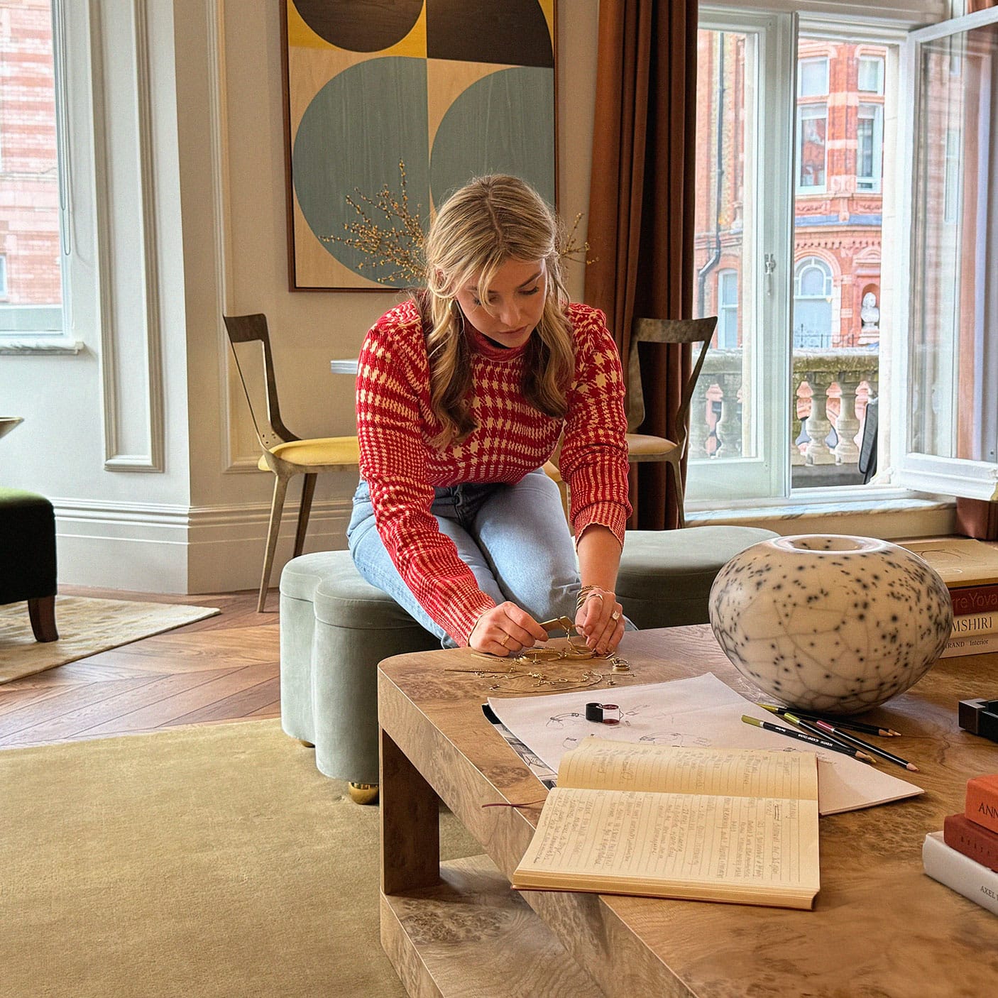 Woman designing jewelry on table at home
