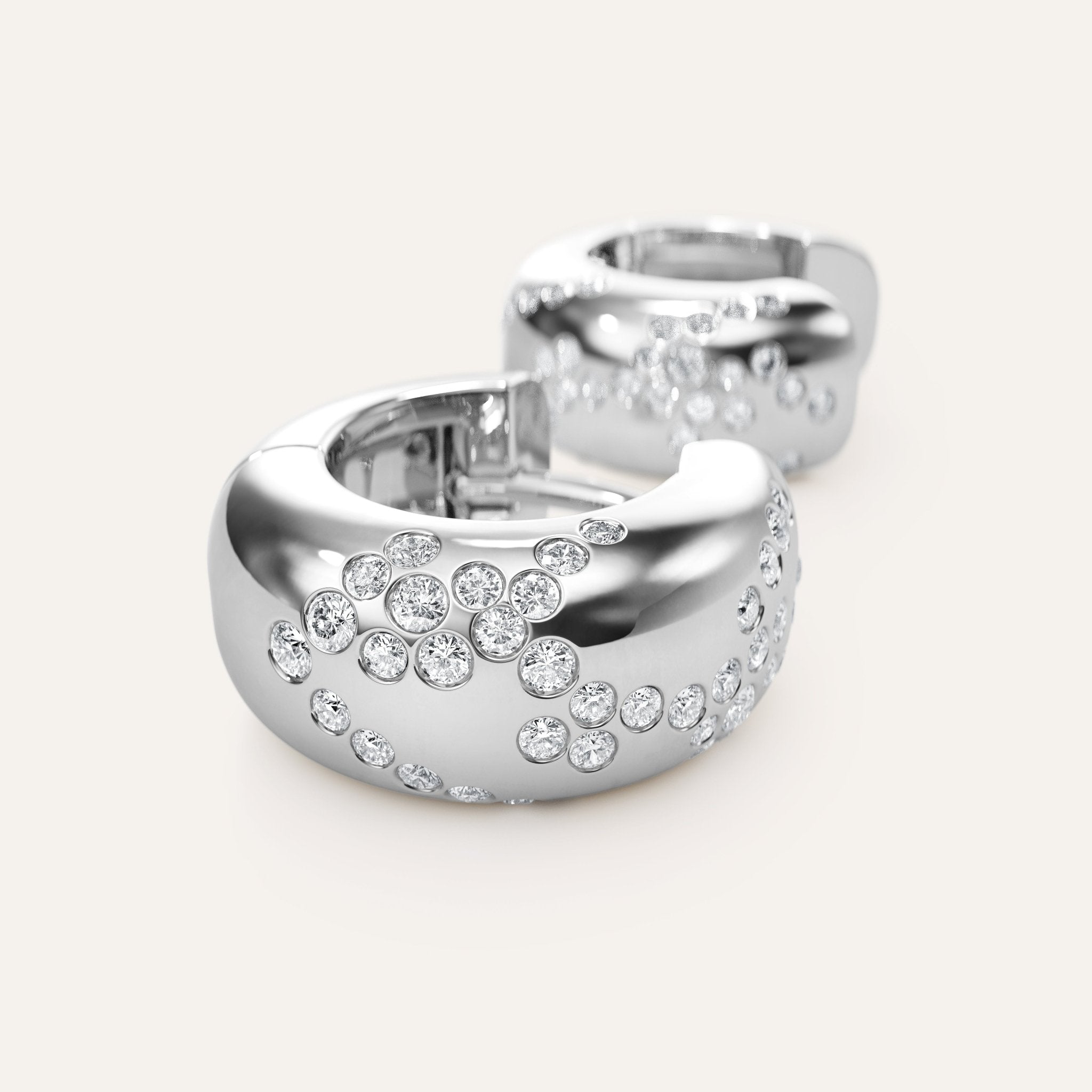 Silver hoop earrings with embedded crystals on a light gray background