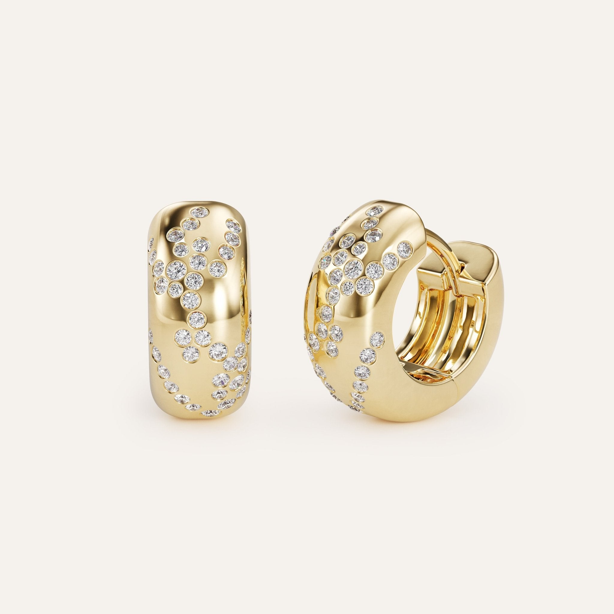 Gold hoop earrings with embedded diamonds on a light beige background