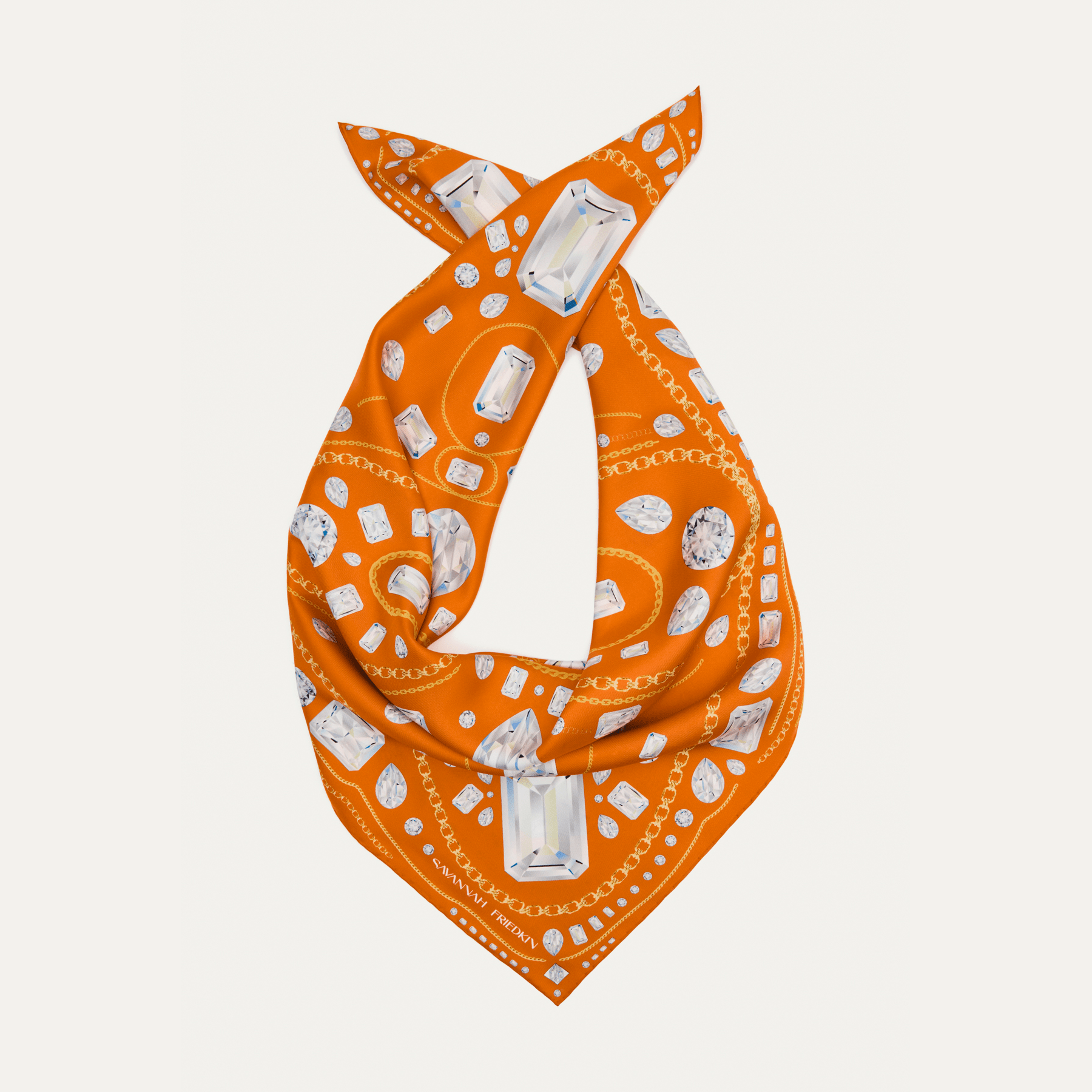 Savannah Friedkin signature orange silk scarf with an all-over diamond and gold chain print, shown knotted into a loose loop against a pale background.