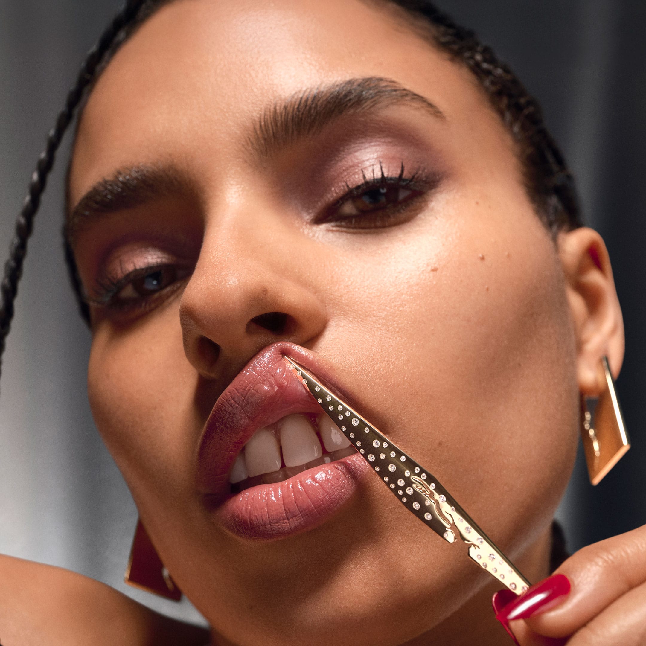 Woman holding jewelry against her mouth