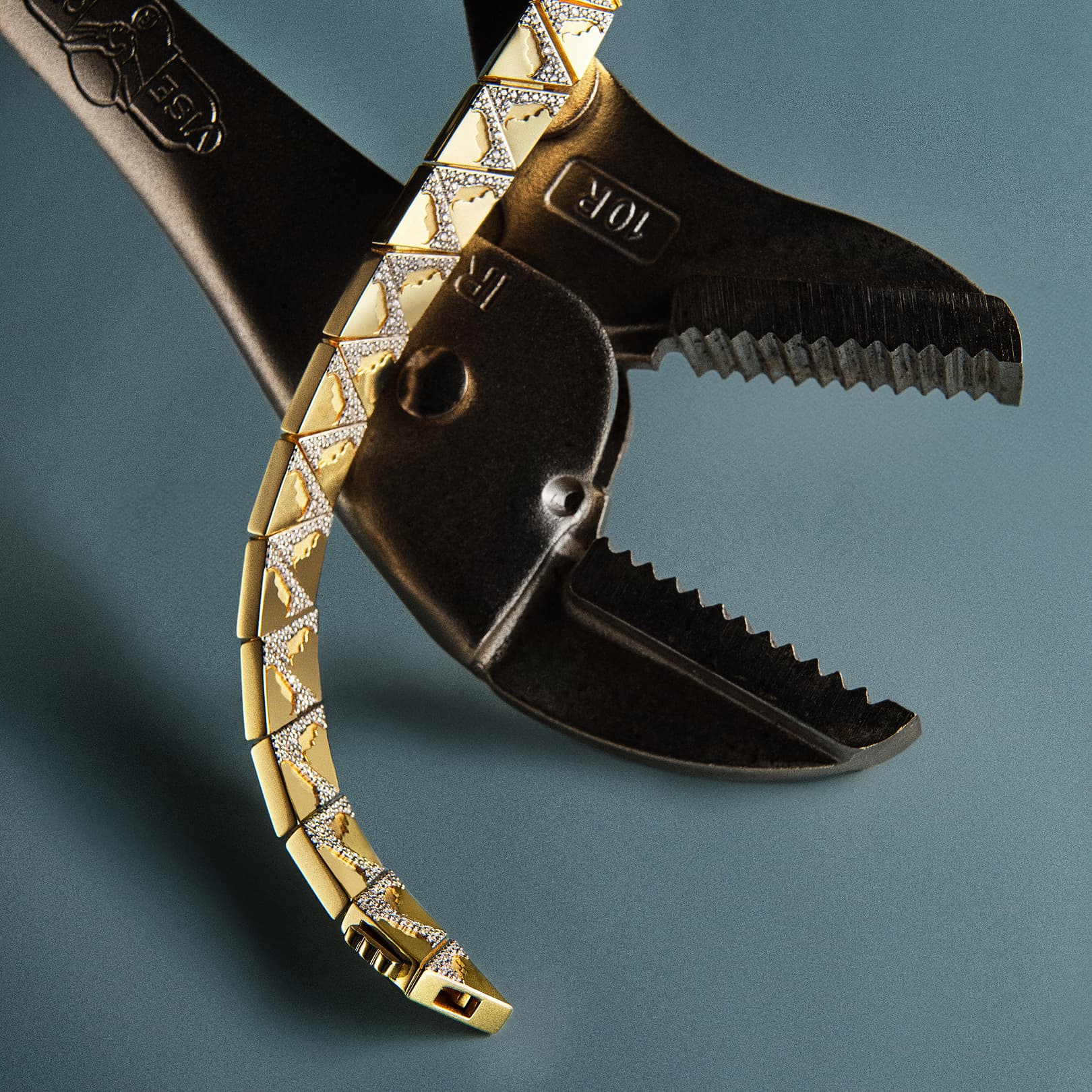 Close-up of a pair of pliers with gold and black handles on a dark background.