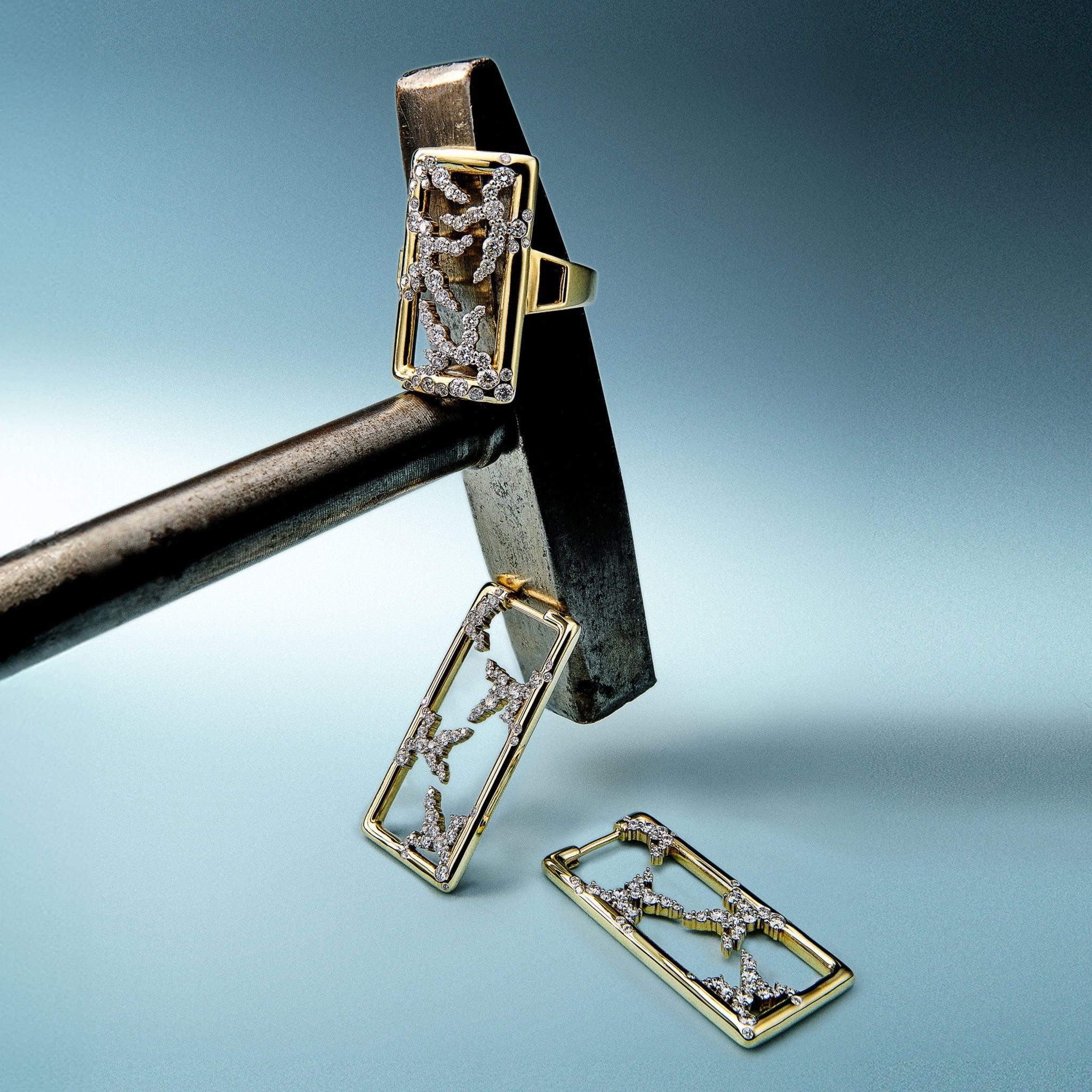 Gold jewelry set with ring, earrings, and pendant on a blue gradient background