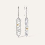 Two 14k white gold diamond drop earrings shown side by side, one face-on and one in side profile, revealing the depth of the openwork pendant construction, pavé wire hook, and yellow gold pyramid spike accent from a three-quarter angle.