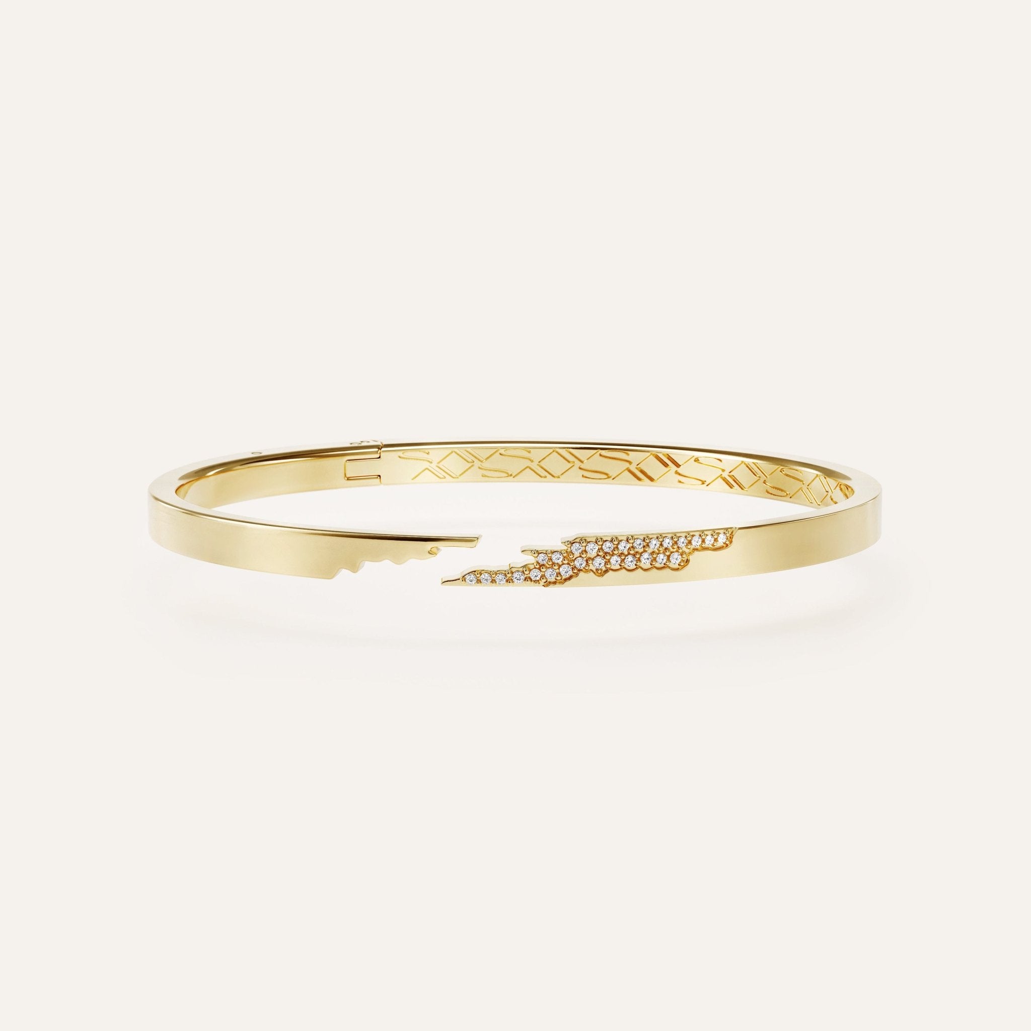 Gold bracelet with intricate design on a white background