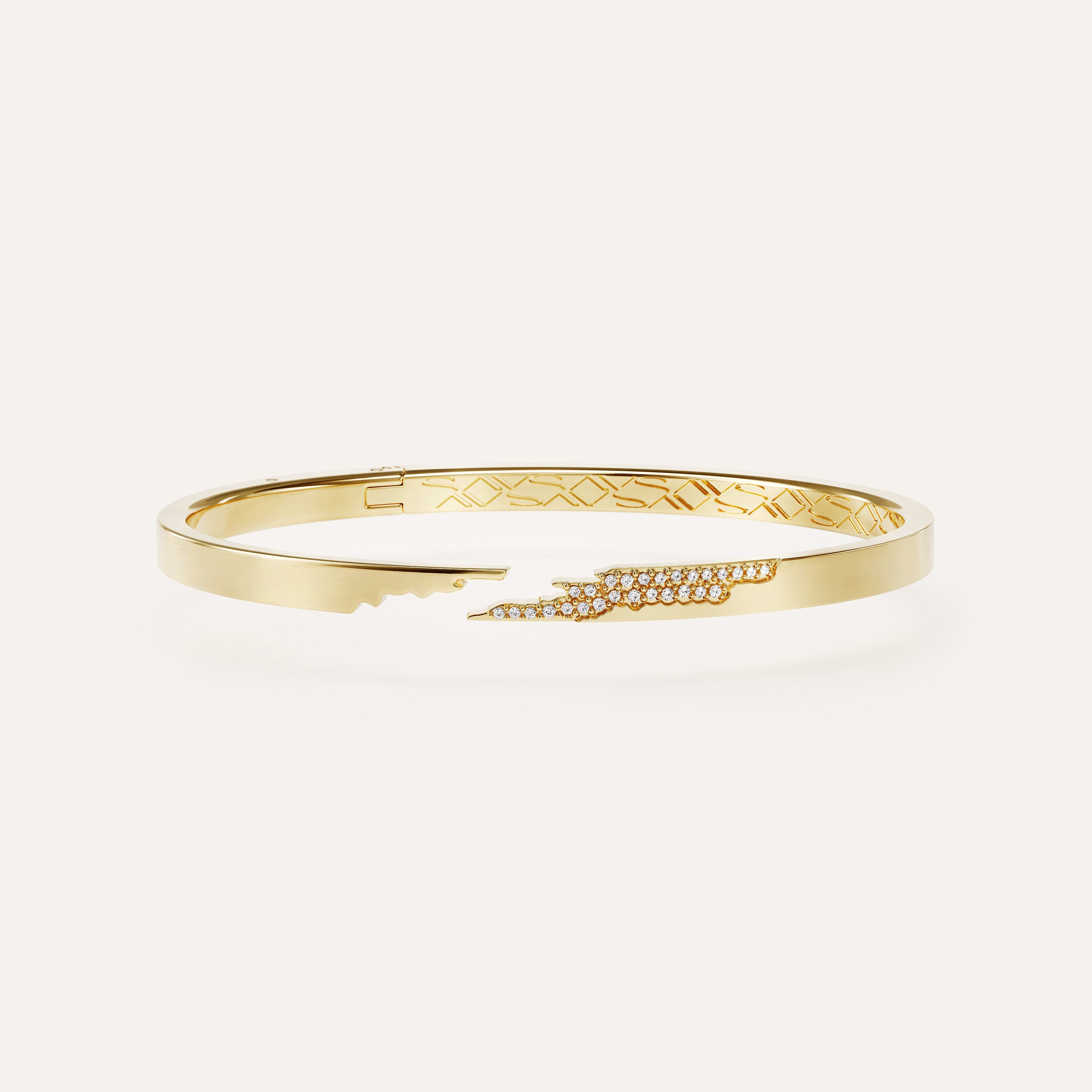 Gold bracelet with intricate design on a white background