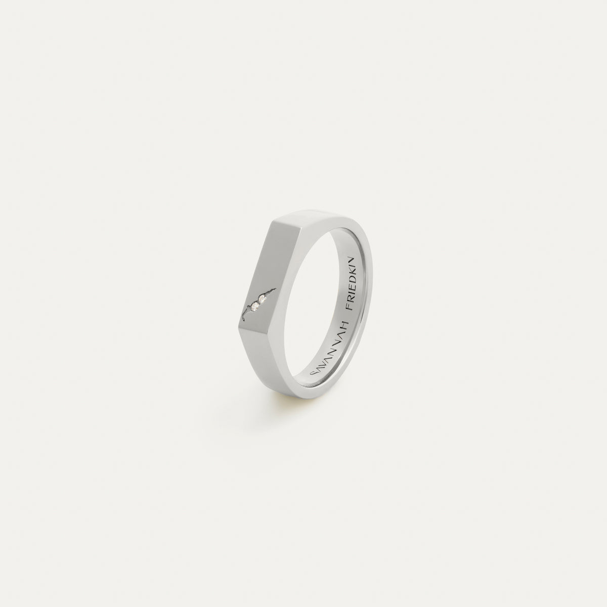 Three-quarter angled view of the white gold lab-grown diamond signet ring showing the flat octagonal face with two flush-set diamonds and engraved crack detail, with the 