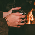 Person holding a mug by a fire