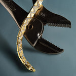 This image features a close-up view of a stylish, broken wide triangle bracelet. The bracelet displays an elegant pattern with gold-colored triangles arranged in a chain-link design, offering a sleek and modern look.